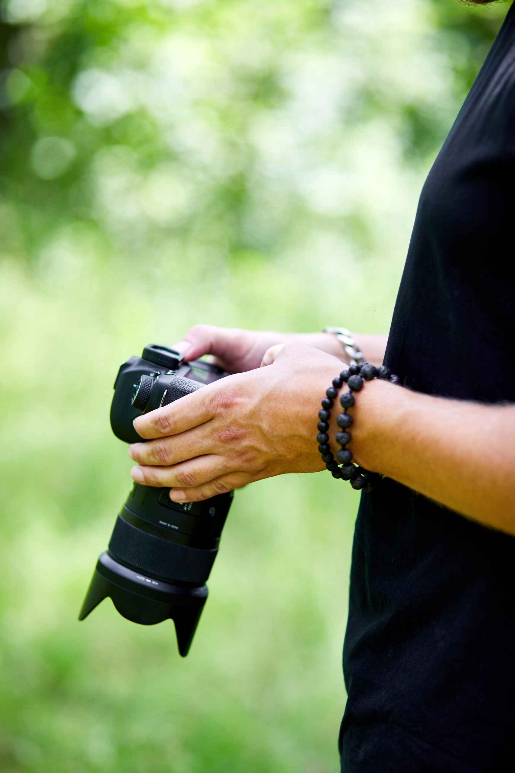 Man photographer with a photo camera in hand outdoor, configures the camera. World photographer day, creative hobby, copy space, place for text, Photography Concepts Professional.
