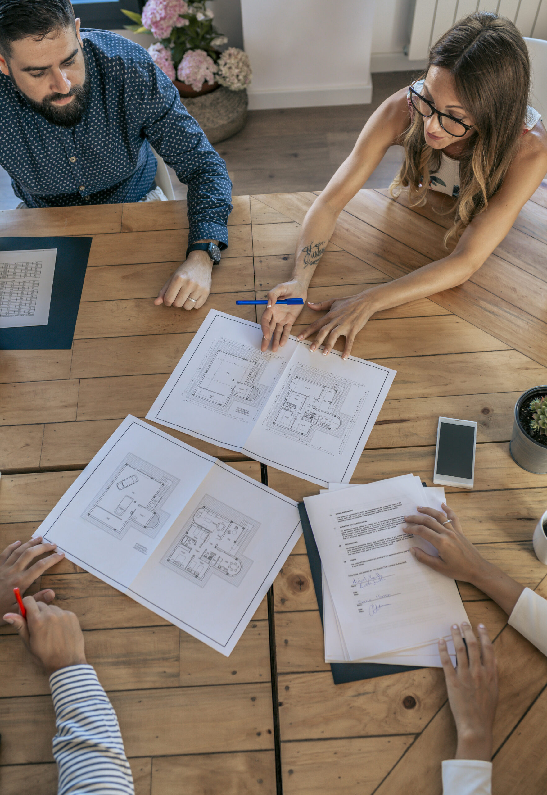 Top view of office workers meeting looking at blueprints and documents